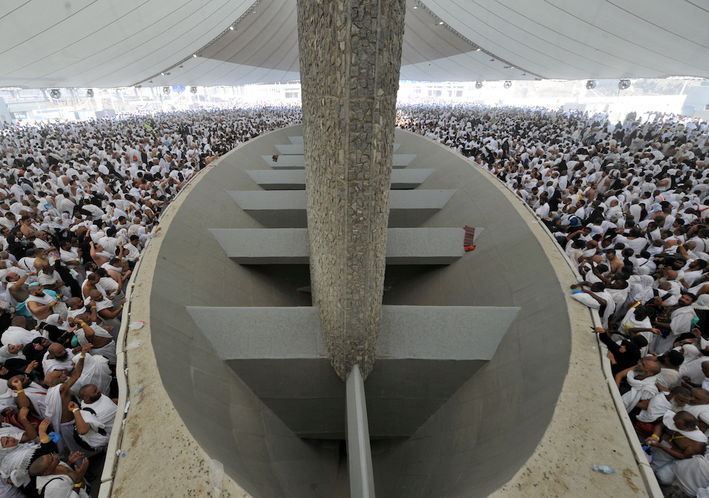 Muslim pilgrims throw pebbles at pillars during the "Jamarat" ritual, the stoning of Satan, in Mina near the holy city of Mecca, on October  26, 2012. Pilgrims pelt pillars symbolising the devil with pebbles to show their defiance on the third day of the hajj as Muslims worldwide mark the Eid al-Adha or the Feast of the Sacrifice, marking the end of the hajj pilgrimage to Mecca and commemorating Abraham's willingness to sacrifice his son Ismail on God's command  in the holy city of Mecca.   AFP PHOTO/FAYEZ NURELDINE (Photo by FAYEZ NURELDINE / AFP)